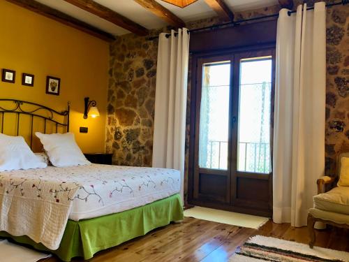 卡拉维亚斯Casa Rural Las Tainas de Carabias的一间卧室设有一张床和一个大窗户