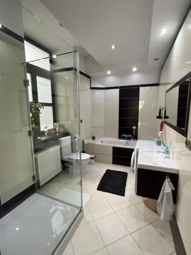 海乌姆Apartament w Centrum przy Studni 102m2的浴室配有2个盥洗盆、淋浴和浴缸。