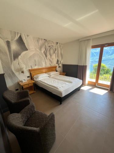 特雷莫西内斯皮纳里酒店的一间卧室配有一张床和两把椅子