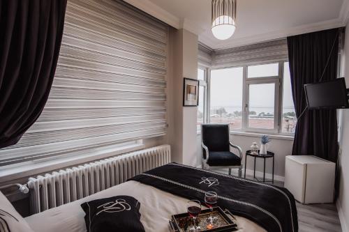 萨姆松Samsun Charme Hotel的卧室配有床、椅子和窗户。