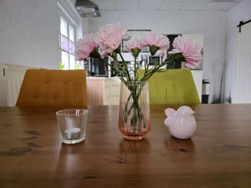 BalveSauerlandluft的木桌边的粉红色花瓶