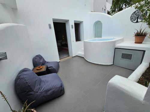 弗通The Muses of Santorini Private Jacuzzi Suites的一个带蓝色豆袋椅和水槽的庭院