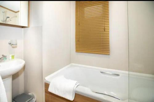 圣安德鲁斯Beautiful 3-Bed Lodge in St Andrews的白色的浴室设有浴缸和水槽。