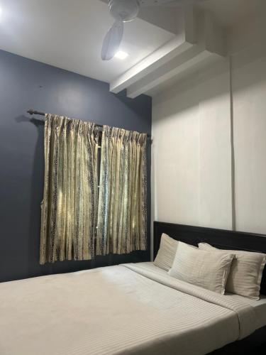 哥印拜陀HOTEL BLUESTONE的一间卧室配有床和带窗帘的窗户