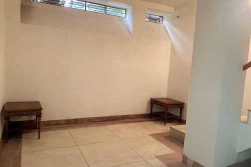 斋浦尔2 Bedroom in C-Scheme, Jaipur的一间设有两张桌子和白色墙壁的房间