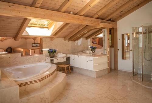 图恩Lakeside Chalet with Panorama View的带浴缸和盥洗盆的大浴室