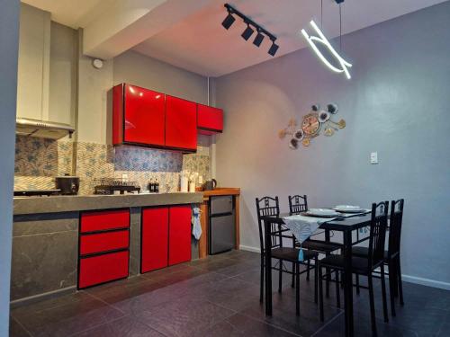 独鲁万S & R Homes的厨房配有红色橱柜和桌椅