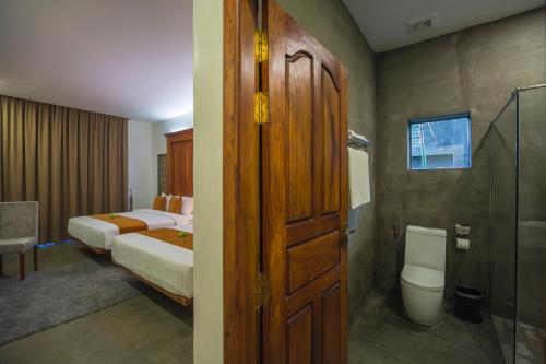 暹粒沃昂酒店和Spa的一间卧室设有两张床、淋浴和卫生间