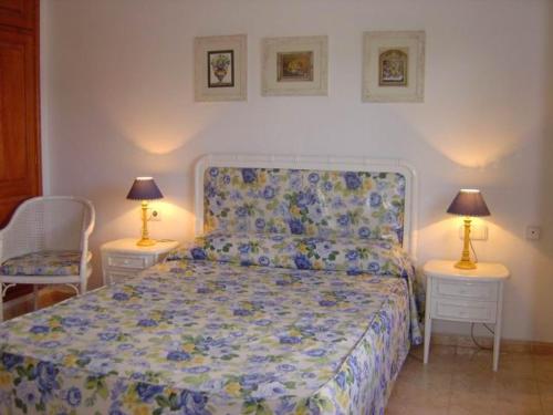 卡门港唐拉斐尔酒店的一间卧室配有一张带两张桌子和两盏灯的床。