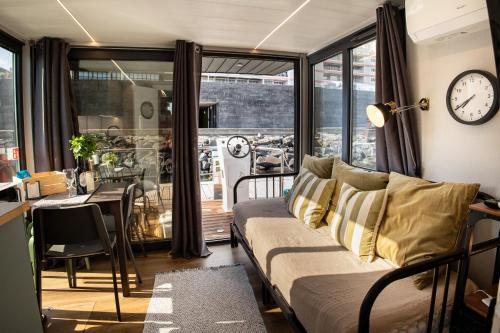 蓬塔德尔加达The Homeboat Company Ponta Delgada-Açores的客厅配有沙发和墙上的时钟