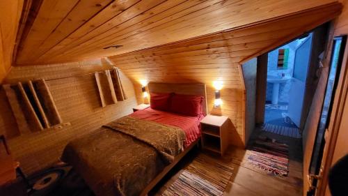 泰斯Bujtina Pllumi Theth的木制客房内的一间卧室,配有一张床