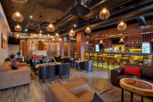 比勒陀利亚Protea Hotel by Marriott Pretoria Hatfield的一间配有沙发的餐厅和一间酒吧