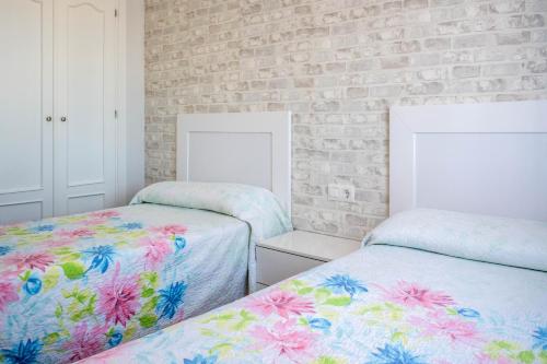科尼尔-德拉弗龙特拉Casas Rurales Pericón的一间卧室设有两张床和砖墙