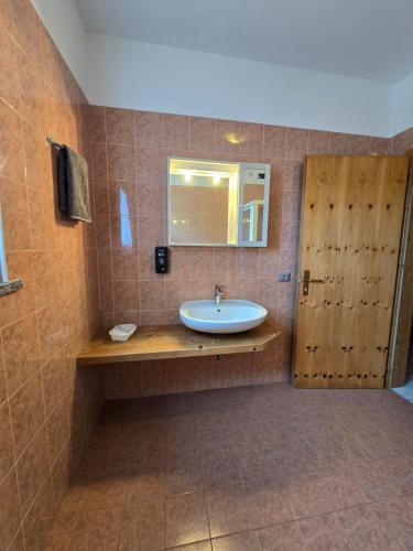 梅佐科罗纳安蒂克菲恩尼尔农庄酒店的一间带水槽和木门的浴室