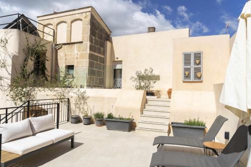波雷雷斯Atrium Suites Mallorca的大楼前带家具和楼梯的天井