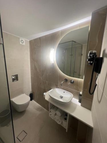 伊西翁阿克泰昂城市酒店的一间带水槽、卫生间和镜子的浴室