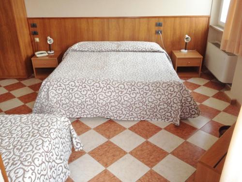 达尔米内戴娜酒店的一间卧室配有一张床,铺有一个 ⁇ 板地板