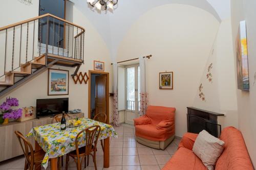米诺利Casa Maria Vittoria的一间带桌子和楼梯的客厅