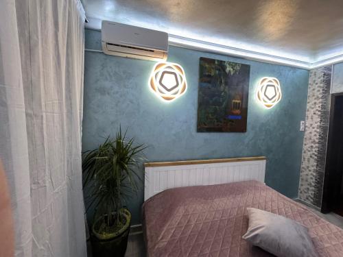 普罗夫迪夫Mini Hotel-Bohemi的卧室配有一张床,墙上有两盏灯