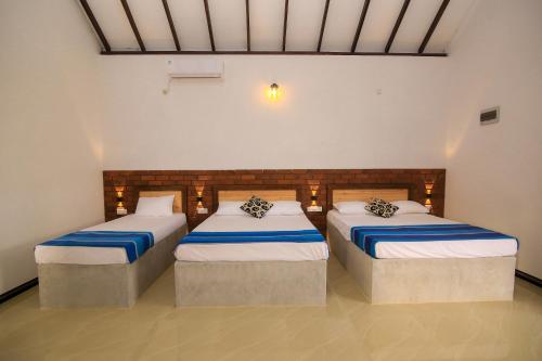 阿努拉德普勒Ari Guest House的一间客房内配有两张床的房间