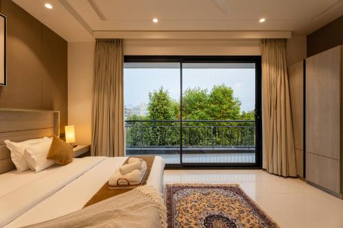 古尔冈The Lodgers Luxury Hotel Near Golf Course Road Gurgaon的一间卧室设有一张床和一个大窗户