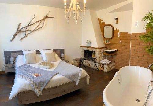 图卢兹La Bulle dans le Palmier的一间卧室配有一张床、一个浴缸和一个吊灯。
