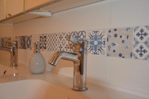拉斯特Windstill Apartments的浴室水槽设有水龙头和瓷砖墙面