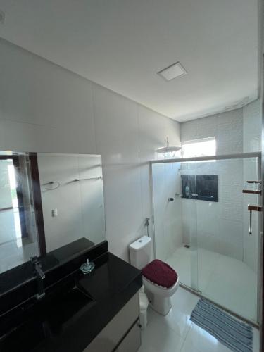 维多利亚-达孔基斯塔Casa com 4 suítes, todas as suítes com ar condicio的一间带玻璃淋浴和卫生间的浴室