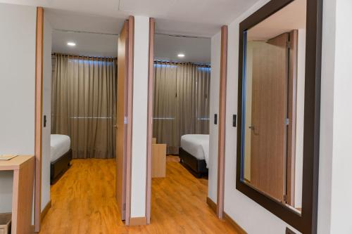 库库塔Hotel Casino Internacional的一间设有两张床的房间和通往卧室的两扇门