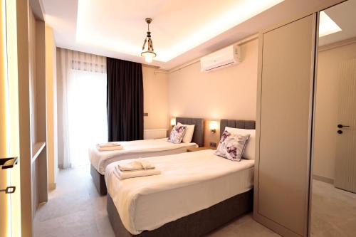 安塔利亚Livia Luxury Apart Hotel的酒店客房设有两张床和窗户。