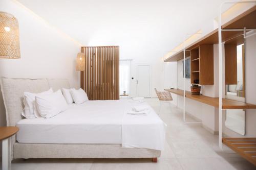 卡尼奥提Lefko Suites的白色的卧室配有白色的床和一张桌子
