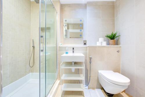 迪拜Dubai Media City Convenient Apartments的浴室配有卫生间、盥洗盆和淋浴。