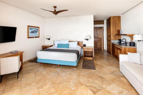 圣何塞德尔卡沃卡波冲浪酒店的一间卧室配有一张床和一张沙发