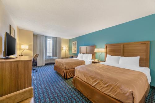 桑达斯基Quality Inn & Suites Sandusky的酒店客房设有两张床和一台平面电视。