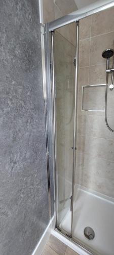 莱姆里吉斯Charnwood Guest House的浴室里设有玻璃门淋浴