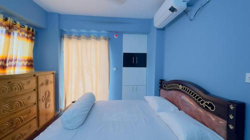 达卡Baridhara Sweet Home的一间蓝色卧室,配有一张床和一个梳妆台