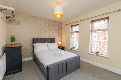 北安普敦Three Bedroom Apartment - Contractors & Groups welcome in Northampton by Centro Stays - Free WiFi & Parking的一间卧室配有一张带白色床单和窗户的床。