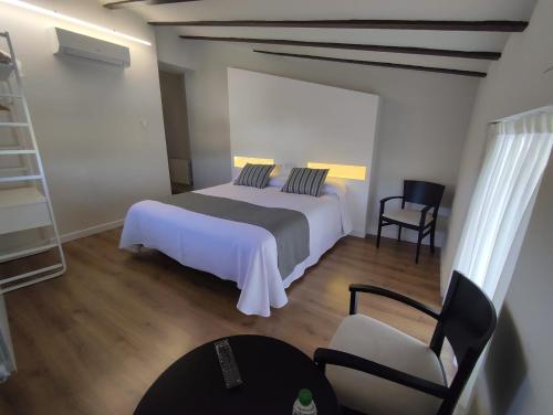 卡拉瓦卡·德·拉·克鲁斯Hotel La Vera Cruz的一间卧室配有一张床和一把椅子