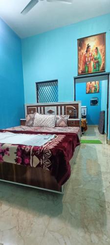 AyodhyaKishori ram guest house 5 minute walking distance from railway station的一间卧室设有两张床和蓝色的墙壁