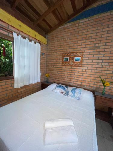 普腊亚罗萨Morada Crisálida的一间卧室配有一张大床和毛巾