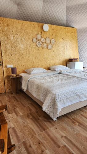伊杰万Yenokavan Glamping的一间卧室设有一张大床,铺有木地板