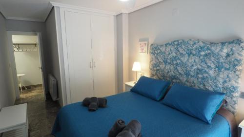 阿尔巴塞特Bonito apartamento en centro ciudad con garaje的一间卧室配有一张蓝色的床,上面有泰迪熊