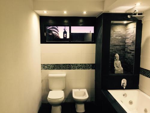 圣格雷戈里奥德波兰科Bali Hotel Boutique的浴室配有卫生间、盥洗盆和浴缸。