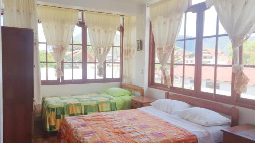 奥克萨潘帕Hospedaje Olguita的一间卧室设有两张床和美景窗户。