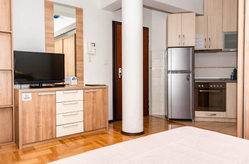 布德瓦Bobo Apartment的厨房配有木制橱柜和冰箱。