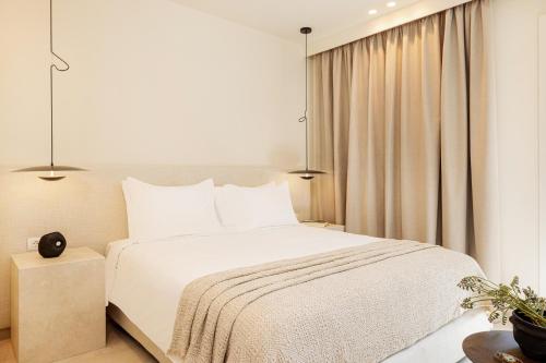 毕达哥利翁Doryssa Method Hotel的卧室配有白色的床和窗户。