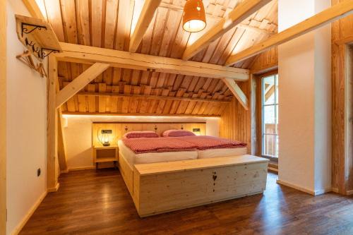 博希尼ALPIK Chalets - Bohinj的一间带一张床的卧室,位于带木制天花板的房间内
