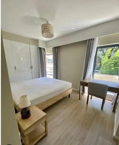 拉巴特Apartement enoure的一间卧室配有一张床、一张书桌和一个窗户。