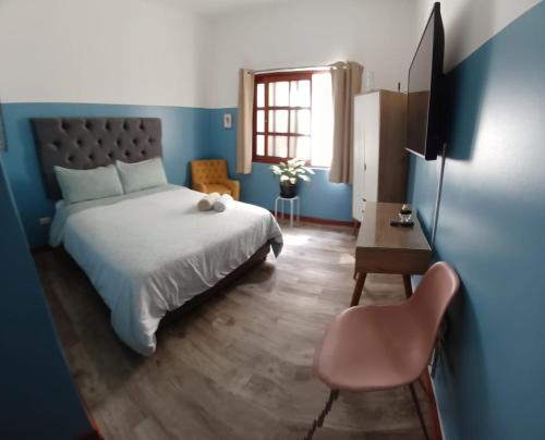 利马Miraflores Kennedy Park的一间卧室配有一张床、一张桌子和一把椅子