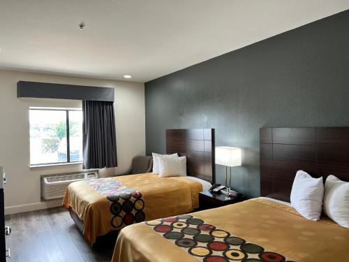 博蒙特Econo Lodge Beaumont I-10 South的酒店客房设有两张床和窗户。